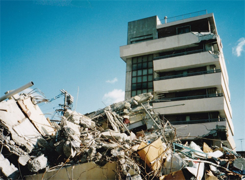 手前のビルは崩壊している。&nbsp;向いのビルは上層部に衝突の跡らしきものがあるがほぼ無事（写真-1）